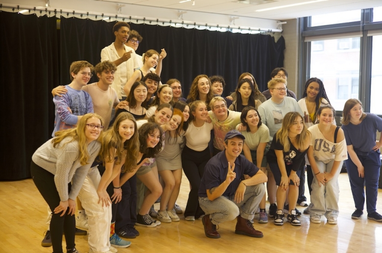 The 2024 Tisch Summer High School Drama class pose for a group photo after their final presentations on the last day of class. Students smile while one or two pose with heart fingers or peace signs.